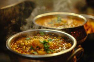 Pots of steaming hot curry, boiling on a stove