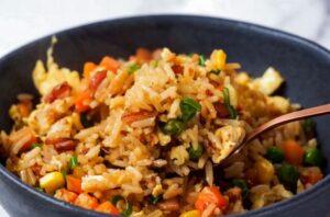 A plate of fried rice with mixed vegetables