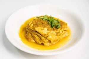 A plate of curry dish on a white table